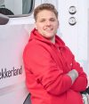 Lekkerland LKW-Fahrer in roter Arbeitskleidung lehnt an Lieferfahrzeug
