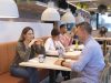 Cafeteria mit Gästen bei Mahlzeiten und Gesprächen