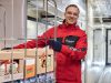Lekkerland Lieferfahrer transportiert Waren auf einem Rollcontainer